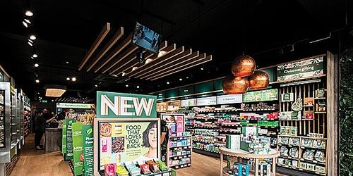 Interior of Holland & Barrett store, featuring a promotional shelf of new food products